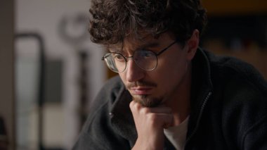 Düşünceli beyaz bir adam evinde satranç oynuyor. Düşünceli bir oyuncu. Oyun stratejisi üzerine kafa yoran bir erkek.