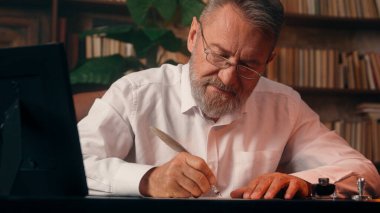 Kendinden emin, yaşlı, beyaz, olgun bir erkek kamera önünde el ele tutuşmuş ofis işadamı yakışıklı, yaşlı çalışan portresi liderinin içindeki iş adamına bakıyor.