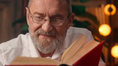 Kendinden emin, yaşlı, beyaz, olgun bir erkek kamera önünde el ele tutuşmuş ofis işadamı yakışıklı, yaşlı çalışan portresi liderinin içindeki iş adamına bakıyor.