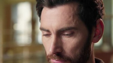 Düşünceli Kafkasyalı iş adamı ciddi düşünen düşünceli erkek portresini kapatıyor. İş işvereni içeride çalışıyor. Orta yaşlı, yeşil gözlü, sağIık vizyonunu yakından görüyor.