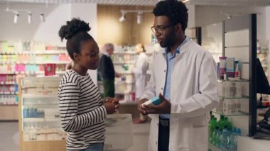 Eczacılık danışmanı Afrikalı Amerikalı erkek eczacı kadın ilaç tavsiyesine yardım ediyor. Eczacı kadın eczanede konuşuyor. Sağlık ürünleri alıyor.