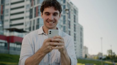 Mutlu Kafkasyalı adam cep telefonu tutuyor. İyi haber. Kazanan iyi haber. Başarılı erkek iş adamı başarısını kutluyor.