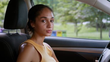 Üzgün Afro-Amerikalı kadın, kadın sürücü otomobil taşıma aracının kameraya baktığını vurguladı.