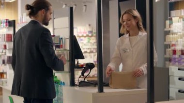 Eczacı kadın, beyaz kadın danışman, eczanede ilaç satıyor. Müşteri, ilaç satın alıyor. Sağlık ürünleri alıyor.