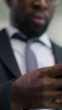 Üzgün, Afro-Amerikalı, erkek, işadamı, akıllı telefon arayan, cep telefonuyla ilgili kötü haberler okuyan, hayal kırıklığına uğramış, üzgün, finansal, dijital bir hata.