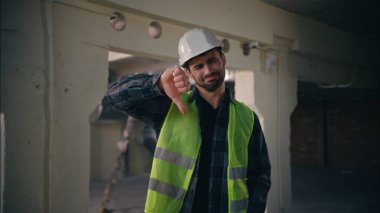 Kafkasyalı mimar, inşaatta baş parmak hareketi gösteriyor. Mutsuz ustabaşı erkek. Onaylamayan tamirci kötü iş.