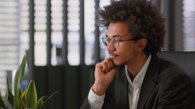 Düşünceli, Afrikalı, Amerikalı, düşünceli, erkek iş adamı, şirkette yaratıcı iş adamı. Düşünceler zor bir başlangıç arar. Ofisin tereddütlerini çözer.