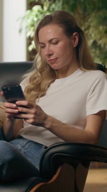 İş kadınlarını cep telefonu kullanırken düşünmek evde cep telefonuna cevap yazmayı düşünmek Kafkasyalı kadın iş kadını serbest çalışan kapalı mekanda oturup akıllı telefon mesajları yazarak sohbet fikri çözümü aramak.