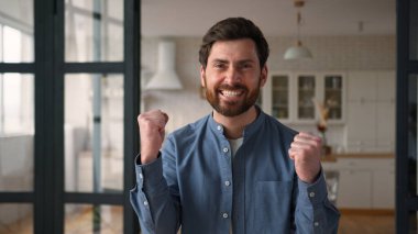 Mutlu, neşeli, beyaz erkek kazanan, gülümseyen, yumruk sallayan, erkek kazanan, ev sahibi, heyecanlı, mutlu, mutlu, mutlu, mutlu bir ebeveyn. Yeni ev kutlama evi