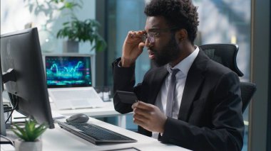 Korkan Afrikalı Amerikalı işadamı, banka kredi kartı yöneticisini elinde tutan erkek işadamı, internet üzerinden para kaybetti. Yanlış şifre sorunu olan adam, bilgisayar arızası yazdı.