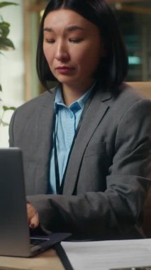 Çok görevli Asyalı Koreli iş kadını, dizüstü bilgisayarda çalışan iş kadını, cep telefonuyla konuşan bir kadın müşteriyle görüşüyor. Gazeteleri kontrol ediyor.