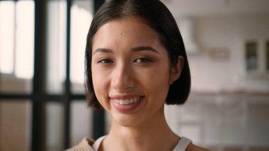 Mutlu Kafkasyalı Latin kadın İspanyol bayan neşeli pozitif duygu ifadesi ev sahibi kadın ev sahibi ev kredisi kameraya bakıp gülüyor sağlıklı dişli gülümseme yakın çekim güzelliği