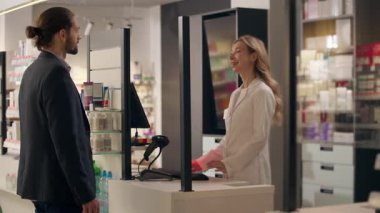Eczane tıbbının müşterisi hasta tıbbi danışman kadın satın alıyor. Eczacı dükkanına yardım ediyor. İlaç siparişi veriyor.