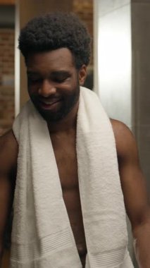 Afrika kökenli, etnik, sağlıklı bir adam, bir bardak su içer, ev banyosu yapar. Çıplak erkek, soğuk su içeceği içer, sağlık hizmetleri alışkanlığı dengeler. H2O ferahlatıcı, nemlendirici.