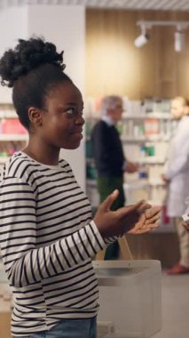 Eczacı, eczacı tavsiyesine yardımcı olur. Eczane sağlık hizmetleri danışmanlığında vitamin satın alır. Afro-Amerikan erkek kadın tavsiyesi.