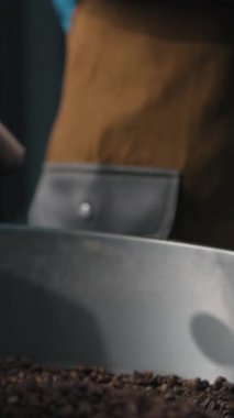 Kızartma makinesinde kızartma yapan organik kahve çekirdekleri mutlu gülümseyen kumaş işçisi Afrikalı Amerikalı erkek erkek adam müfettiş denetleme kontrol kontrol prodüksiyon işi memnun notlar yazmak