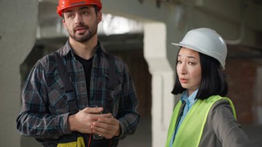 Çok uluslu kızgın mühendisler yanlış anlaşılma inşaat tartışması Asyalı kadın Kafkas erkek güvenlik kask yapısı iletişimi gerginlik oluşturma projesi anlaşmazlığına işaret ediyor