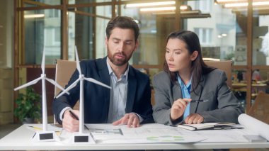 Ekonomi projesini tartışan çok uluslu iş adamları yatırım rüzgar türbini modeli Koreli sürdürülebilir enerji işkadını Kafkasyalı iş adamı takım çalışması çevre planlama yeniliği yeşil başlangıç