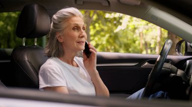 Kafası karışmış, Kafası karışmış, yaşlı, yaşlı, yaşlı, yaşlı bir kadın olgun araba sürücüsü, araba sahibi, büyükannesi otomobil ulaşımında cep telefonuyla konuşan, akıllı telefonlardan konuşan, şehirdeki GPS 'i kaybetmiş.