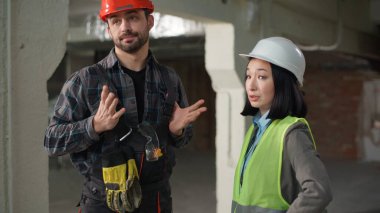 Çok uluslu kızgın mühendisler yanlış anlaşılma inşaat tartışması Asyalı kadın Kafkas erkek güvenlik kask yapısı iletişimi gerginlik oluşturma projesi anlaşmazlığına işaret ediyor