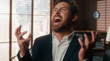 Gülümseyen mutlu orta yaşlı iş adamı gülüyor bağırarak başarıya ulaşıyordu yetişkin işadamı işvereni ofiste kameraya bakıp çığlık çığlığa bağırıyordu yüksek sesle stres kazanıyordu neşe dolu tepkiler kazanıyordu