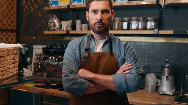 Kafkasyalı, beyaz, girişimci, barista, personel müdürü, portre sahibi, garson, kollarını çaprazlayan, orta yaşlı erkek, kafeteryada kameraya bakan, küçük işletme catering endüstrisi.