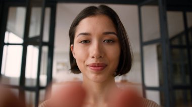 Web kamerası bakış açısı POV İspanyol kadın gülümseme gen z kullanıcı kız etkilenen kadın parmaklar cep telefonu yazma mesaj ekranı dokunmatik akıllı telefon görüntüleme online sohbet aleti bağımlısı evde