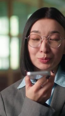 İş kadını gülümseyen ses mesajı ofisteki Asyalı iş kadınına ses mesajı gönderiyor mikrofonla konuşuyor Koreli Çinli mimar kızla sohbet ediyor hoparlörden konuşuyor.