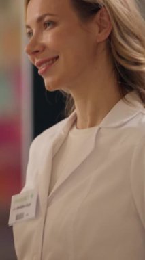 Kadın eczacı ilaçları, eczane vitaminleri, eczane ilaçları, gülümseyen beyaz kadın danışman, eczane asistanı.