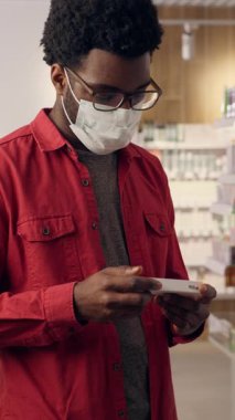 Eczane sağlık hizmetlerindeki Afrikalı erkek müşteri. Kafkas kadın eczacı. Koronavirüs antiviral hapları. İlaç.