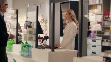 Tıbbi danışman kadın eczacı eczanede reçeteli ilaç reçetesine yardım ediyor eczaneden ilaç alıyor yaşlı bir adamın ilaç sipariş etmesine yardım ediyor vitamin tedavisi görüyor.