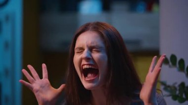 Stresli, öfkeli, öfkeli, Kafkasyalı çılgın, üzgün kız gece yarısı evinde bağırıyor, çaresizce bağırıyor, duygusal öfke çığlıkları atıyor, çıldırmış kadın öfkesi bağırıyor, hiddetleniyor.