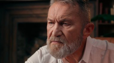 Kendinden emin, yaşlı, beyaz, olgun bir erkek kamera önünde el ele tutuşmuş ofis işadamı yakışıklı, yaşlı çalışan portresi liderinin içindeki iş adamına bakıyor.