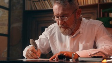 Kendinden emin, yaşlı, beyaz, olgun bir erkek kamera önünde el ele tutuşmuş ofis işadamı yakışıklı, yaşlı çalışan portresi liderinin içindeki iş adamına bakıyor.