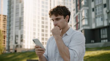 Kendine güvenen Kafkasyalı genç adam elinde cep telefonu akıllı iş adamı şehir merkezindeki mekanı araştırıyor internetteki erkek internet GPS navigasyon uygulaması cep telefonu uygulaması