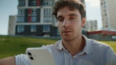 Beyaz adam ekrandaki cep telefonuna bakıyor akıllı telefon teknolojisi internetteki sohbet mesajları sosyal ağlar erkek işadamı iş adamı şehir içi iletişimi zımbırtısı.