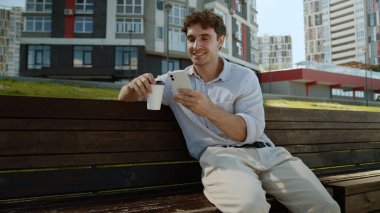 Kafkasyalı bir adam cep telefonuyla kahve içiyor akıllı cep telefonu online çalışan girişimci internet sosyal medya komik gülüşlü iş adamı erkek iş adamı şehir yöneticisi adam açık havada eğleniyor