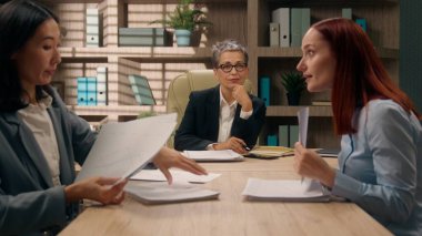 İş adamları grup evraklarını tartışıyor iş kadınları iş arkadaşları Kafkas Asyalı kadın ofis kadınları meslektaşlarını analiz ediyor ortaklar konferans belgelerini özetliyor.