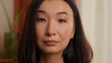 Ciddi ciddi düşünceli Asyalı Çinli kadın kameraman kız iş kadını, etnik eş ev hanımı ev sahibi ev sahibi kiracı vesikalık işine bakıyor.