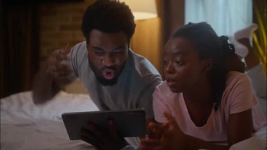 Öfkeli çılgın hayranlar Afro-Amerikan çift sevgili tablet kullanıyor. Sinir gazı kullanıyor. Spor takımını destekliyor.