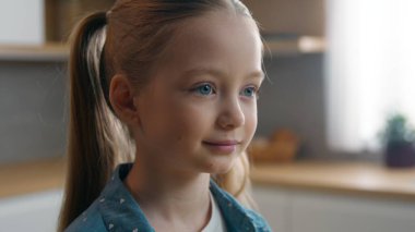 Ev mutfağındaki yakın plan portre. Evdeki beyaz kız mutlu bir gülümseme. Evin önünde neşeli bir vesikalık resim.