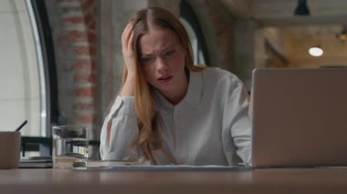 Aşırı çalışan Kafkasyalı iş kadını, ofis işvereni kız işkadını, masa başında dizüstü bilgisayar yazarak yanlış veri çözme sorunu hakkında notlar yazarak kafa yoruyor.