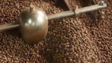 Fabrika aromalı kahverengi tanecikleri karıştırarak endüstriyel karıştırma makinesinde kavrulmuş kahve çekirdekleri karıştırılıyor kakao kızartılıyor yakın çekim üretim süreci kafein dağıtımı yapılıyor