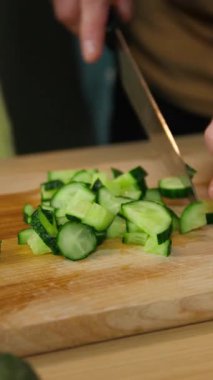 Mutfakta mutlu bir beyaz aile birlikte yemek pişiriyor baba salatalık kesiyor kız çocukla taze sebze vitamin salatası pişiriyor çocuk aşçı çocuk yemek pişiriyor yemek malzemelerini yakın akşam yemeği dağıtıyor