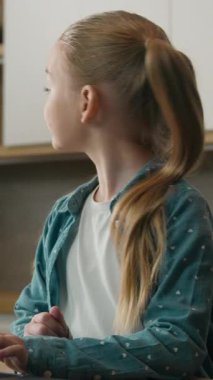 Mutfakta gülümseyen beyaz bir aile, dizüstü bilgisayarla çalışan küçük bir kız çocuğu bilgisayar oyunu oynayan bir baba, yanında likör suyu olan iki bardak getiriyor.