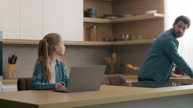 Beyaz kız öğrenci kız öğrenci öğrenci öğrenci. Mutfaktaki dizüstü bilgisayarla evde okuyor. Kilit altında mutlu aile çocuk bakımı sırasında erkek ebeveyn babasından destek talep ediyor.