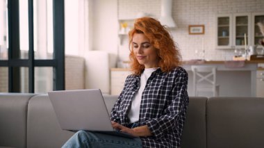 Gülümseyen Kafkasyalı kadın kadın serbest çalışan kız öğrenci e-öğrenim işi internet bilgisayarı dizüstü bilgisayarı internet alışverişi ev kanepede internet sohbet teknolojisi satın alma