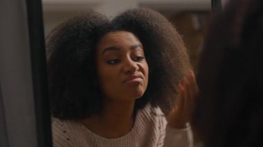 Üzgün, sinirli, stresli, Afro-Amerikalı kadın, aynanın yansımasına bakan, yüzüne dokunan, cilt rengi, kırışıklıkları, iğrenç, yaşlanan yüz derisi kavramı.