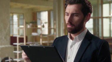 Düşünceli bir iş adamı ofiste evrak yazıyor. Düşünceli bir erkek işadamı plan analizi düşünüyor. Şirket sözleşmesi imzalıyor.