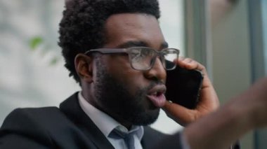 Öfkeli iş adamı Afrikalı Amerikalı iş adamı erkek uzman modern ofis profesyonelinde cep telefonuyla konuşuyor stresli konuşma, iş yeri sorunları, stres sorunları, hüsran